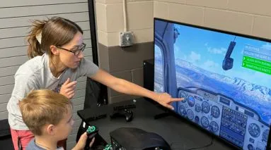 Student helping child on video game