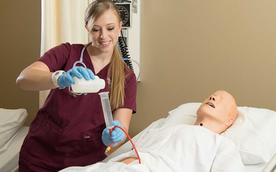 Nursing Student pouring medication into syringe.